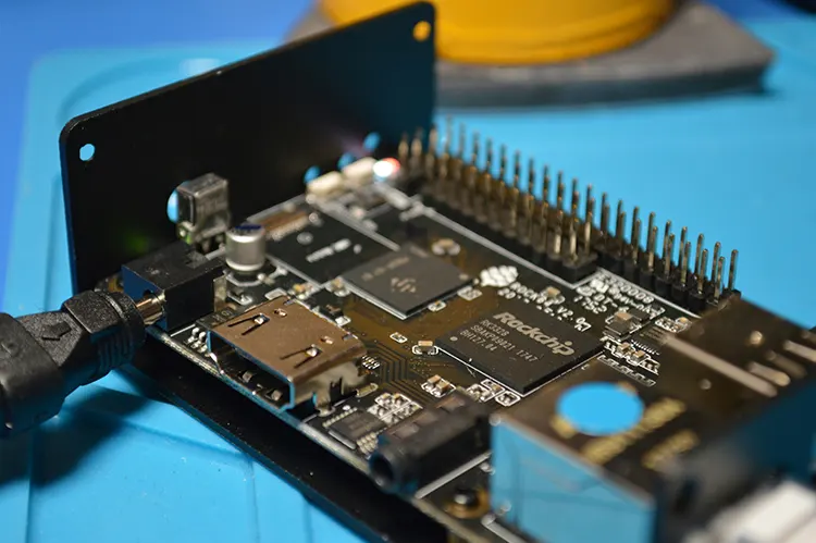 Close-up of a custom embedded hardware board with microchips, connectors, and pin headers, representing electronic engineering and product development.
